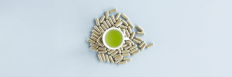 Cup of green tea surrounded by capsules symbolizing how long L-theanine lasts in the body and its absorption timeline.